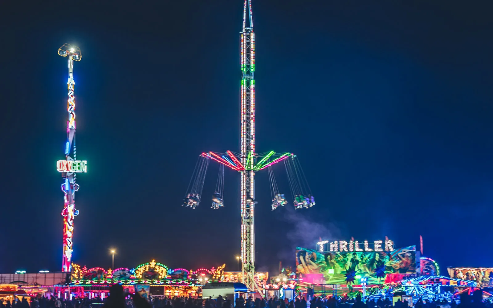 Illuminated fairground rides at night at the festival